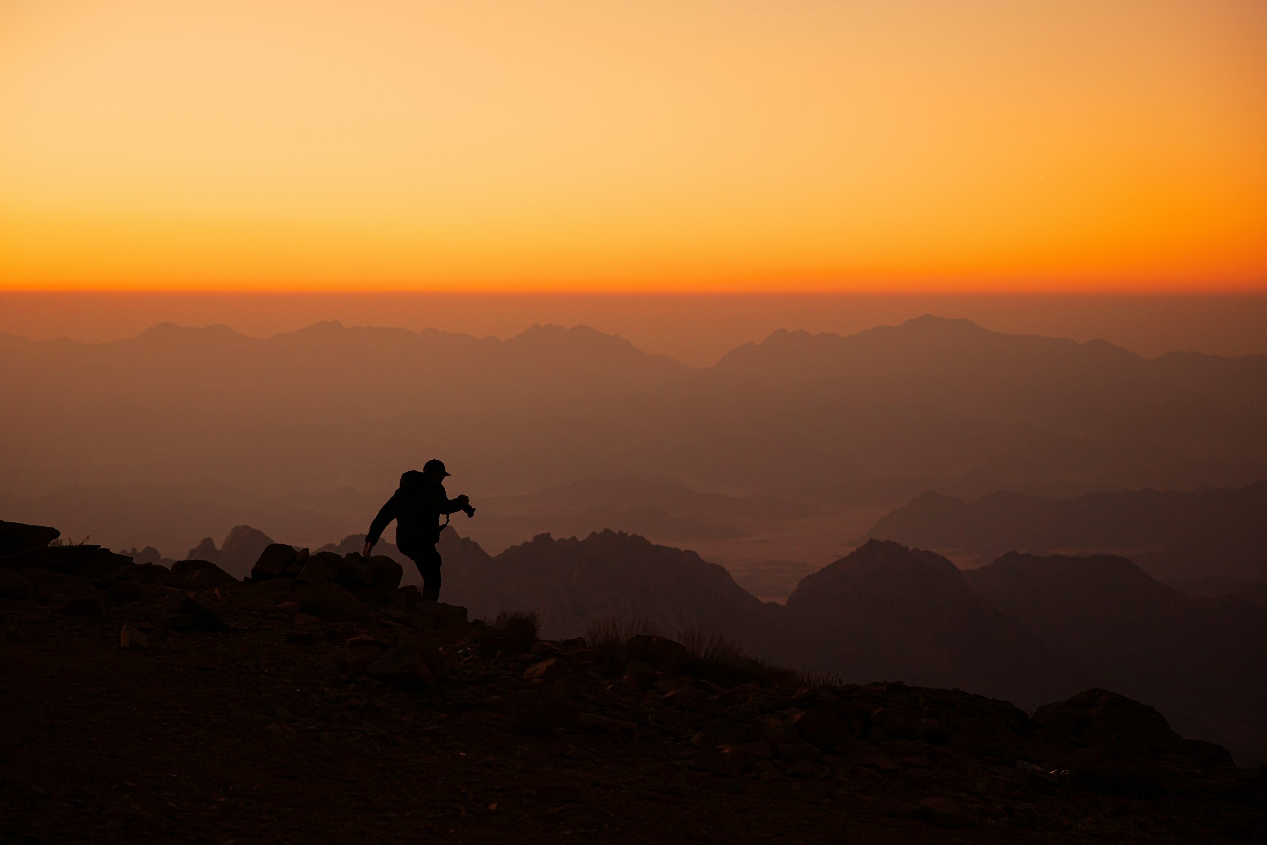 A hiker stays cool under the summer sun on a trail, practicing hiking in hot weather safety.