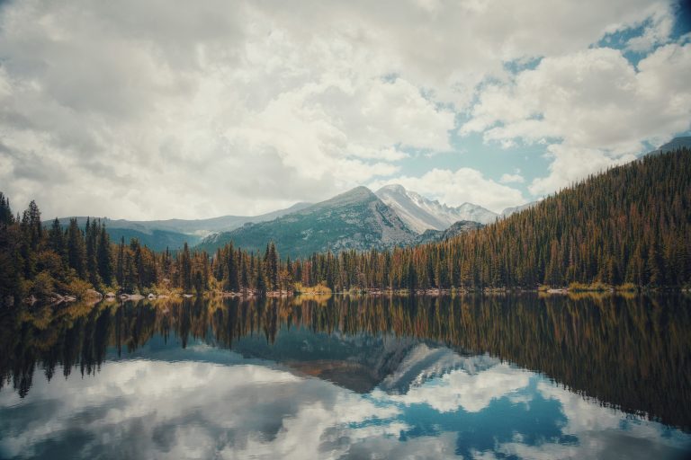 Scenic view of Bear Lake with pine forests and mountains on the Bear Lake Trail in Rocky Mountain National Park.